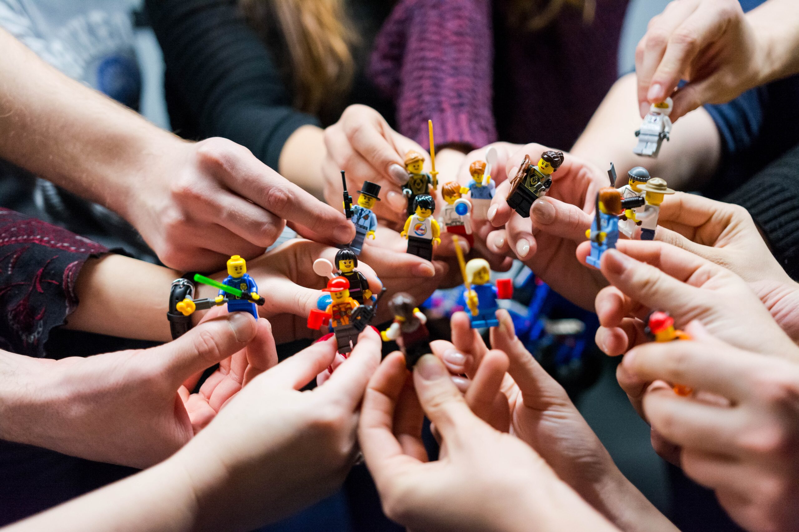 Ludzie trzymający w dłoniach figurki LEGO